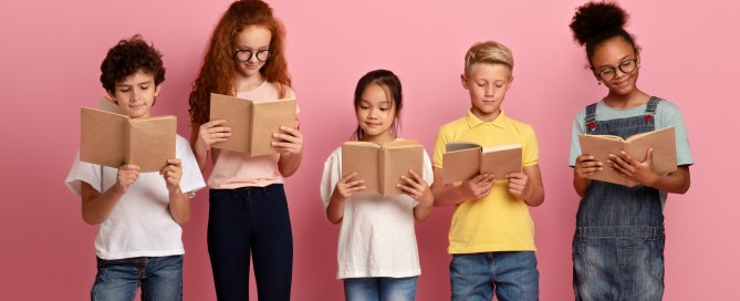 Picture of five children of different races reading books together.