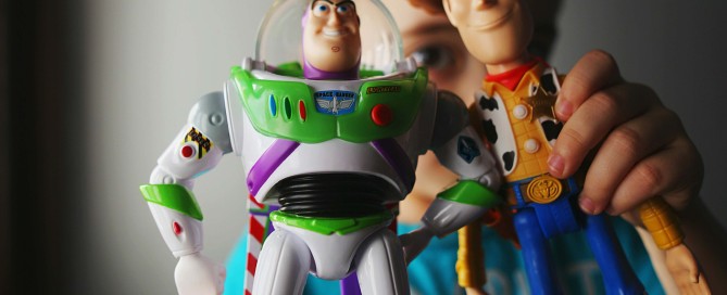 Photo of a boy holding Woody and Buzz Lightyear from the movie Toy Story.