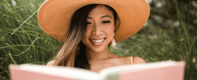 Photo of a woman outside reading a book.